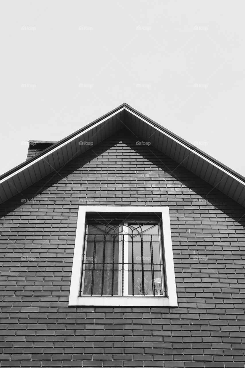 roof of a brick house with a window