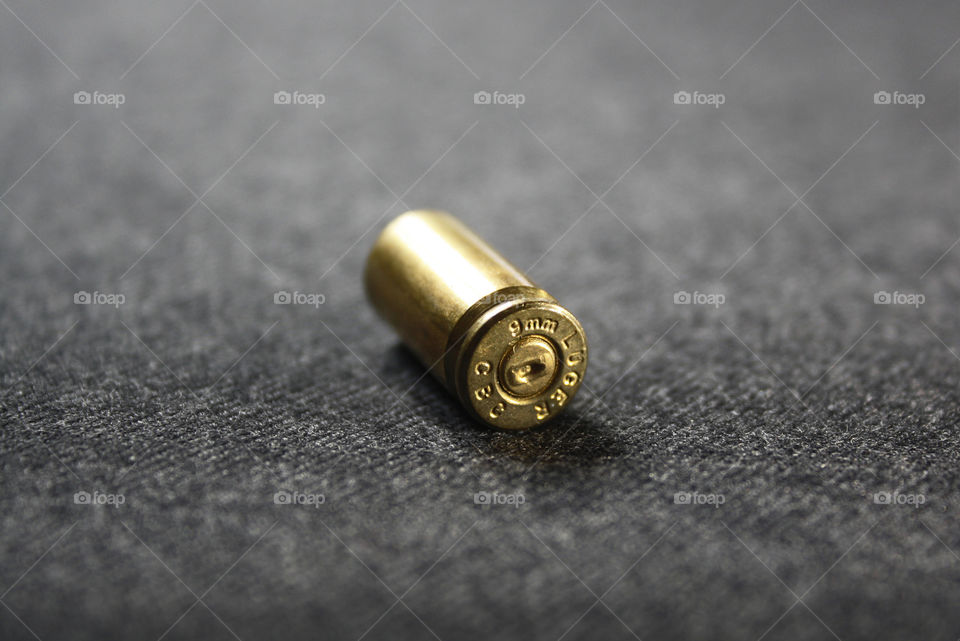 Golden metal bullet shell on grey background