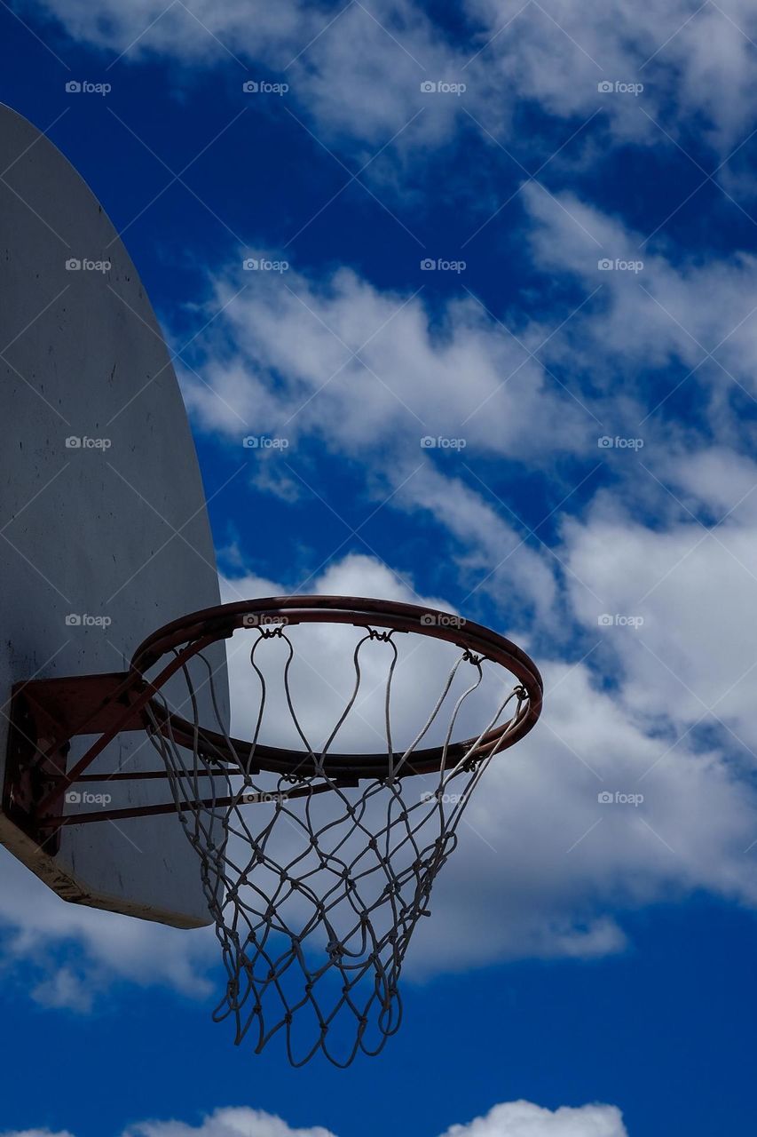 Basketball hoop in the sky, on the basketball court, looking up at the hoop, shooting hoops, basketball net angle, looking up at the net 