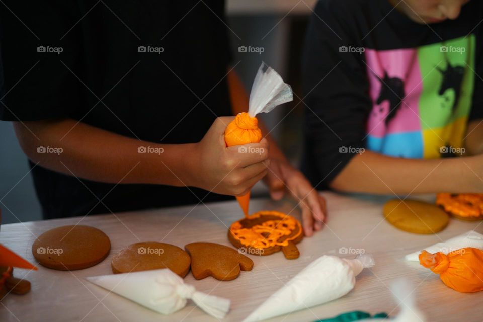 seven year old boy decorating handmade cookies for Halloween