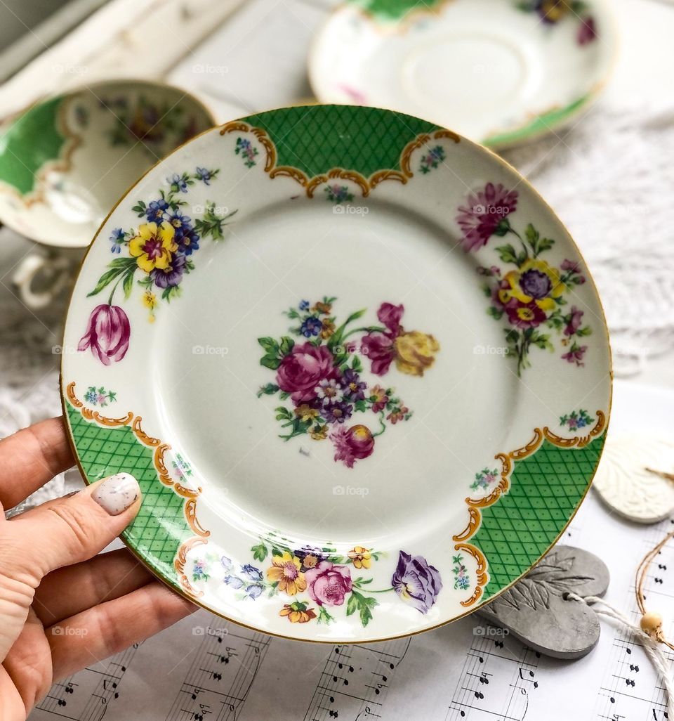 Antique beige porcelain plate with green ornament and flowers