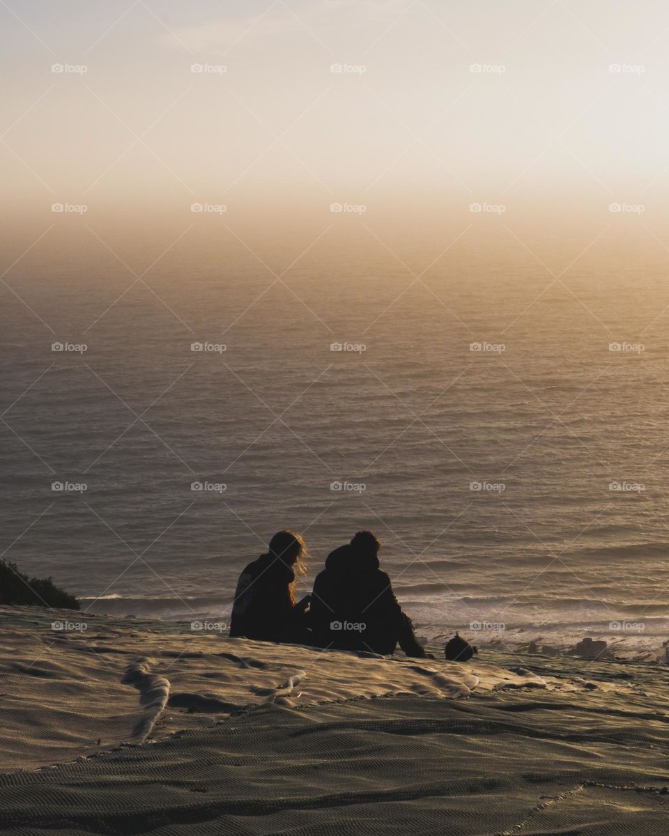 Couple enjoying the beautiful sunset at the coastline having lovely memories 