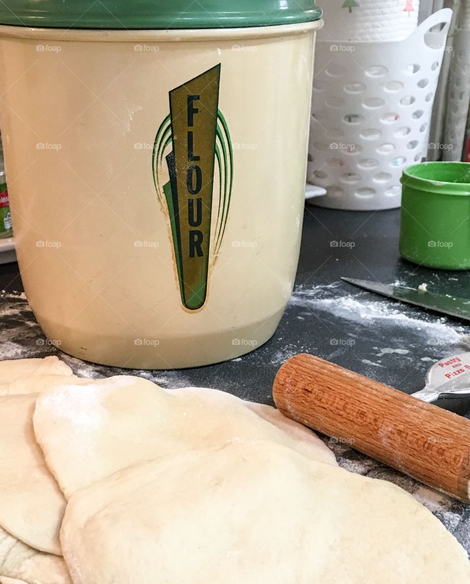 Rolling out the flour dough with rolling pin  for homemade pita bread 