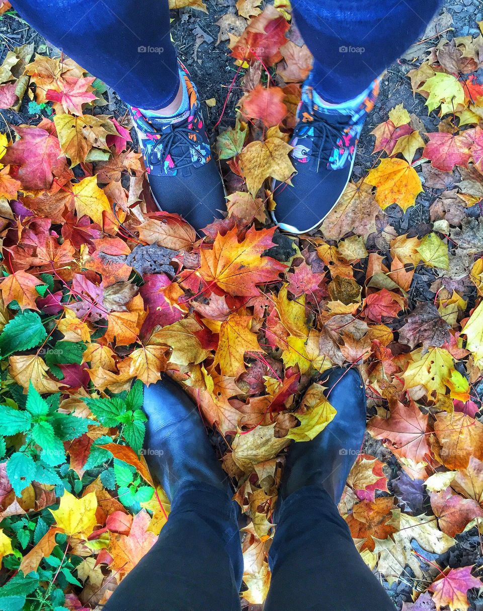 Human foot on the autumn leaves