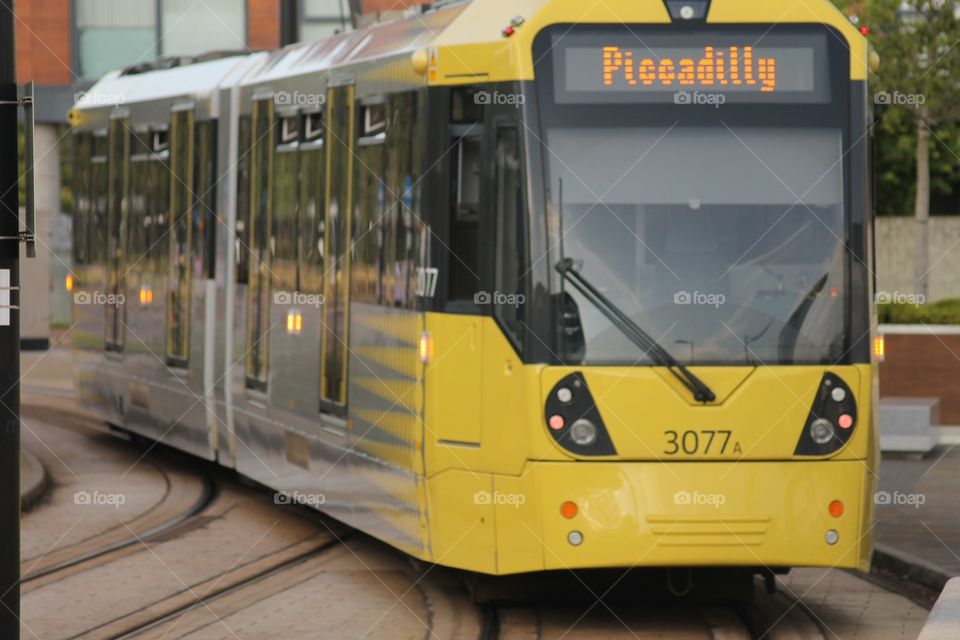 Tram commute. Yellow tram en route to Piccadily