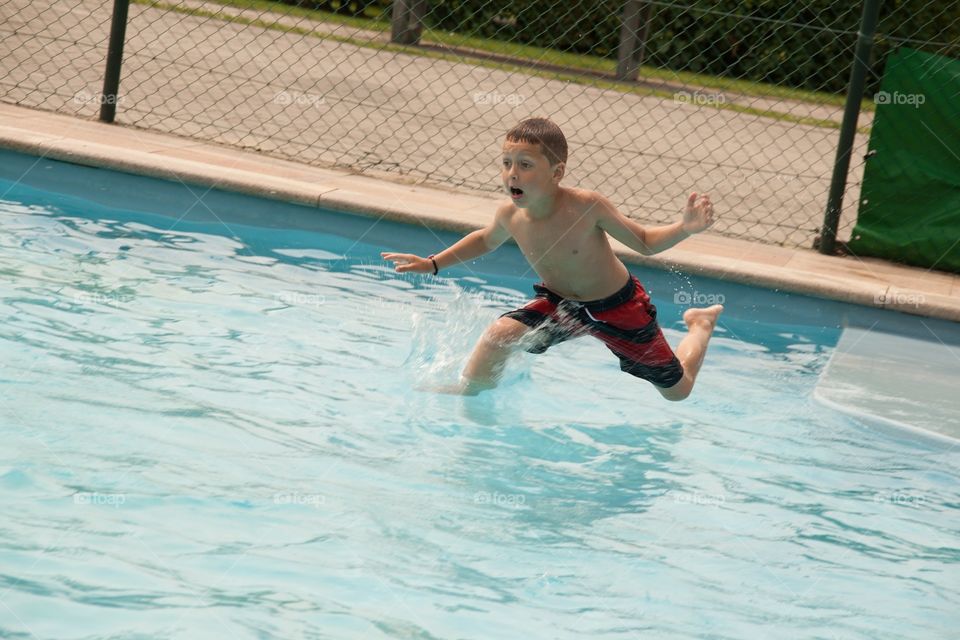 My little boy jumping and being playful in the water
