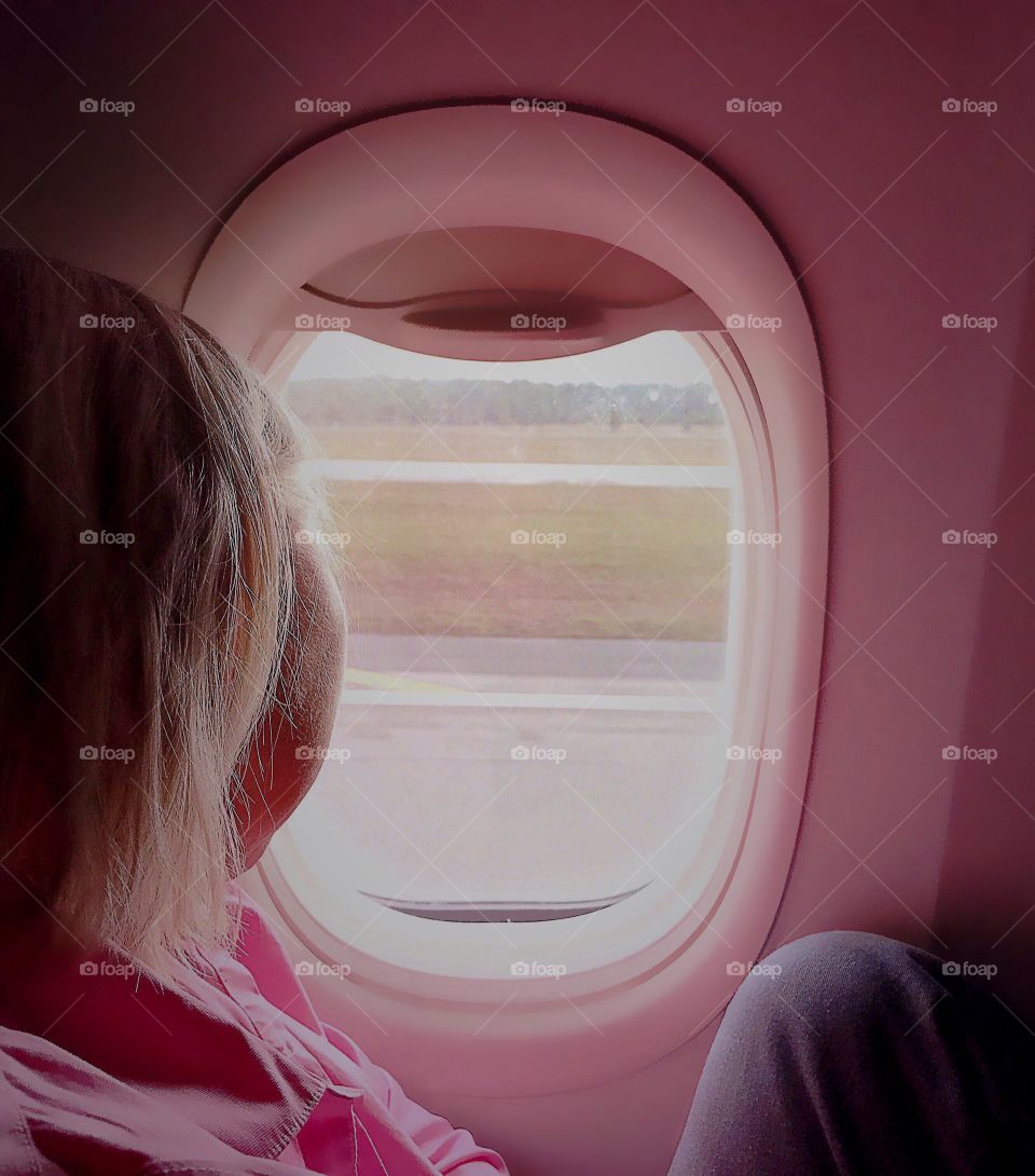 Business commuter enjoying the the view from the aircraft’s window before her work begins.