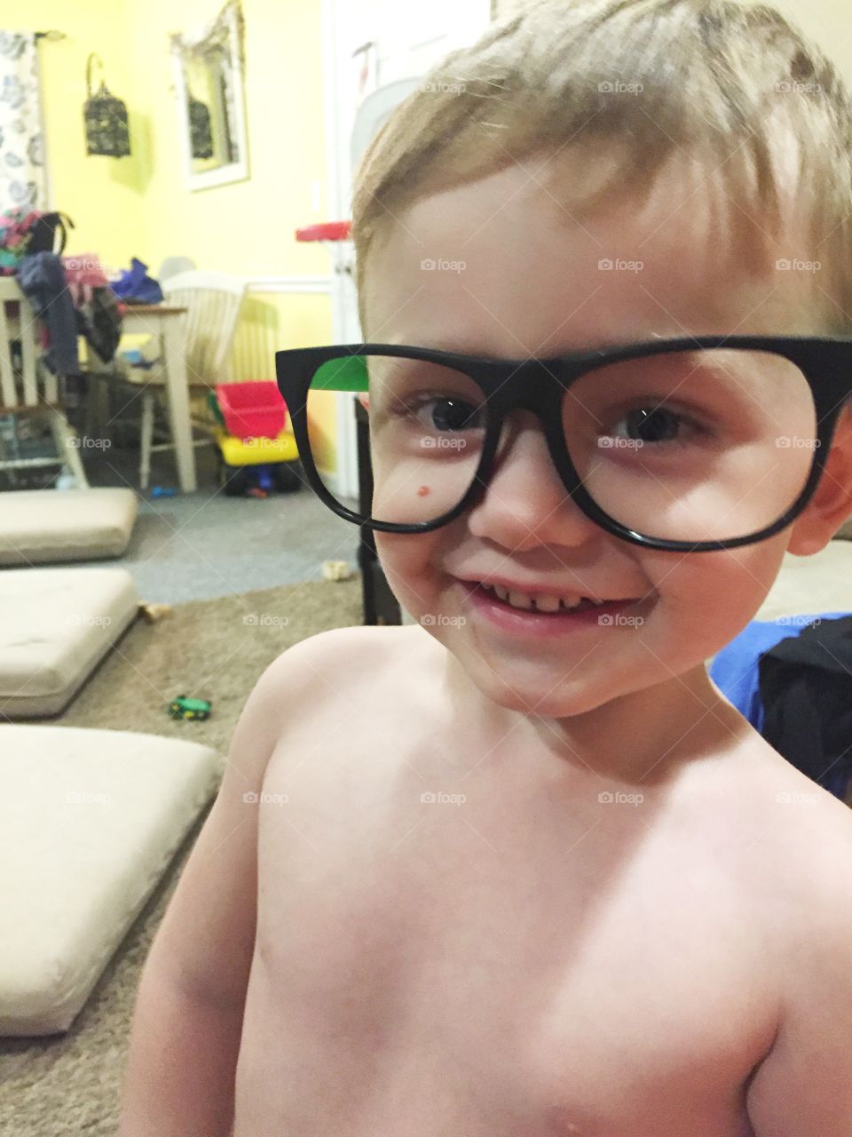 Shirtless boy with large spectacles