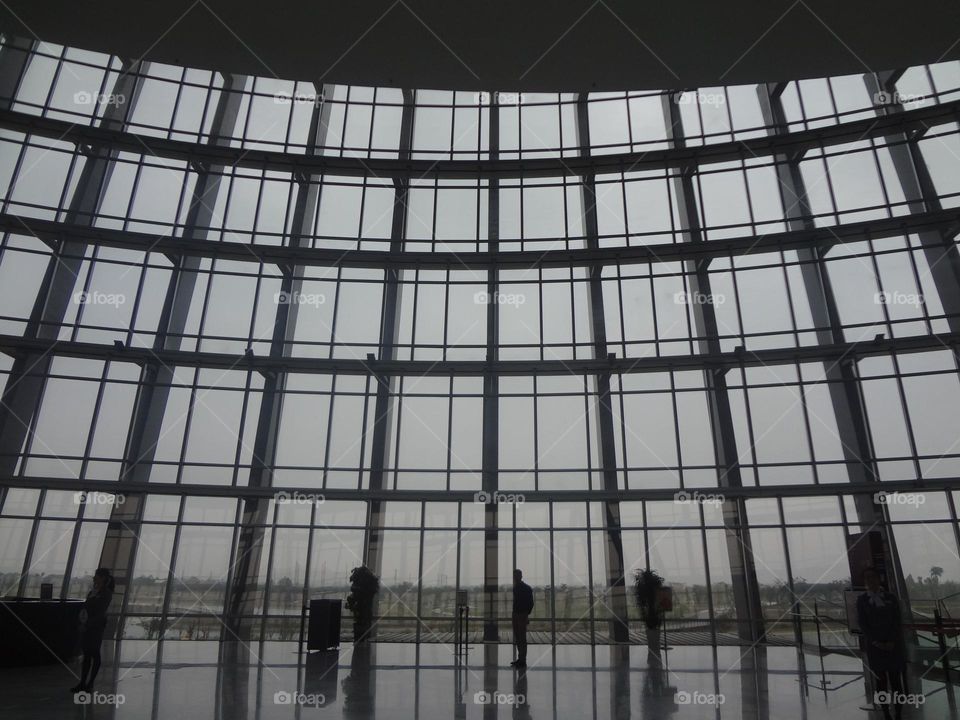 A man starring at a glass wall full of windows