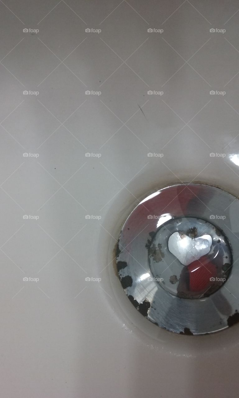 Heart shape drop of water on sink drain