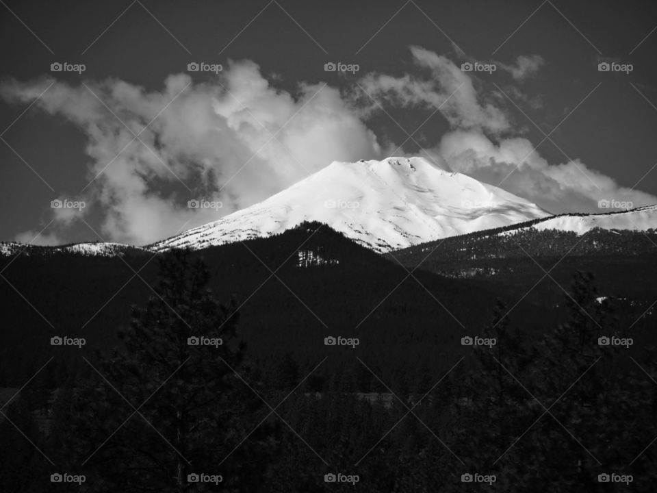 Clouds blow by a snow covered Mt. Bachelor in the Cascade Mountain Range of Oregon. 