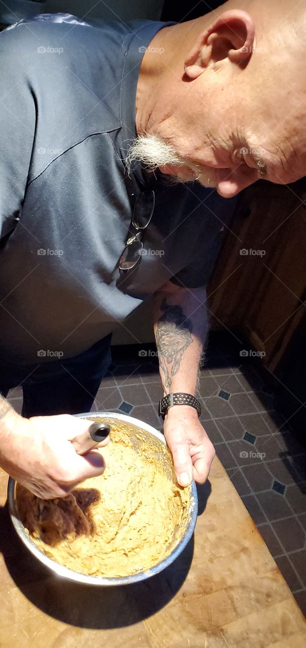Man wisking & baking muffins. ready to pour into muffin pans. This is with sweet potatoes in it.