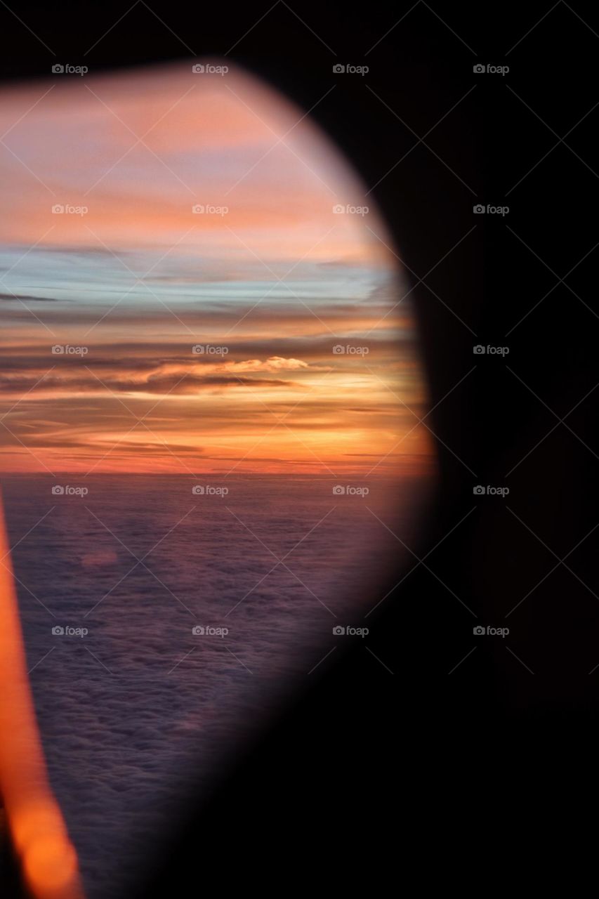 View through an airplane window of the sunrise over the Atlantic Ocean