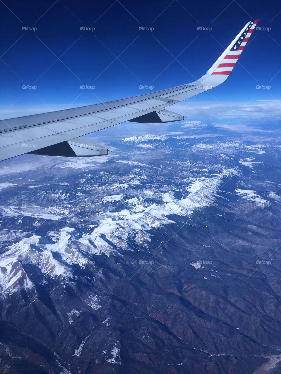 Plane wing parallels mountain range