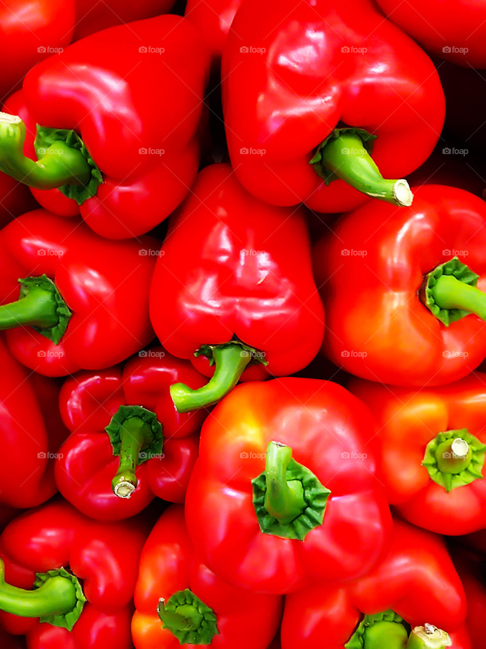Natural background made of many Red ripe sweet peppers with green peduncles 