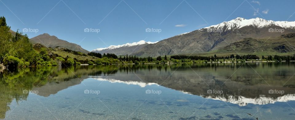 Reflection of mountain and trees in calm lake