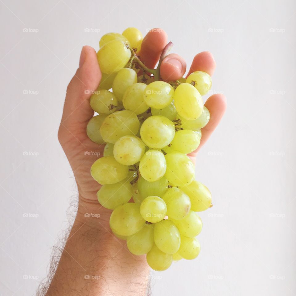 Close-up of hand holding white grapes 