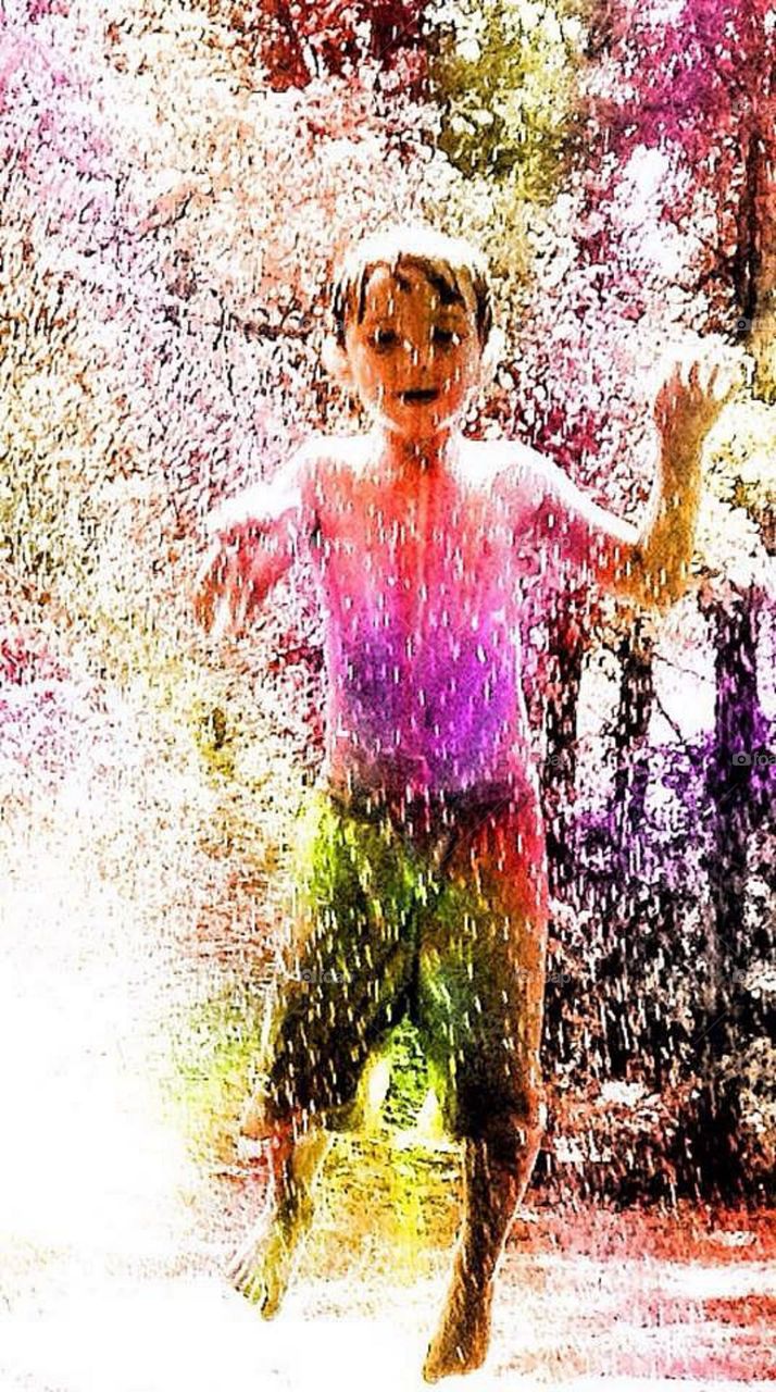 Little boy playing water splash