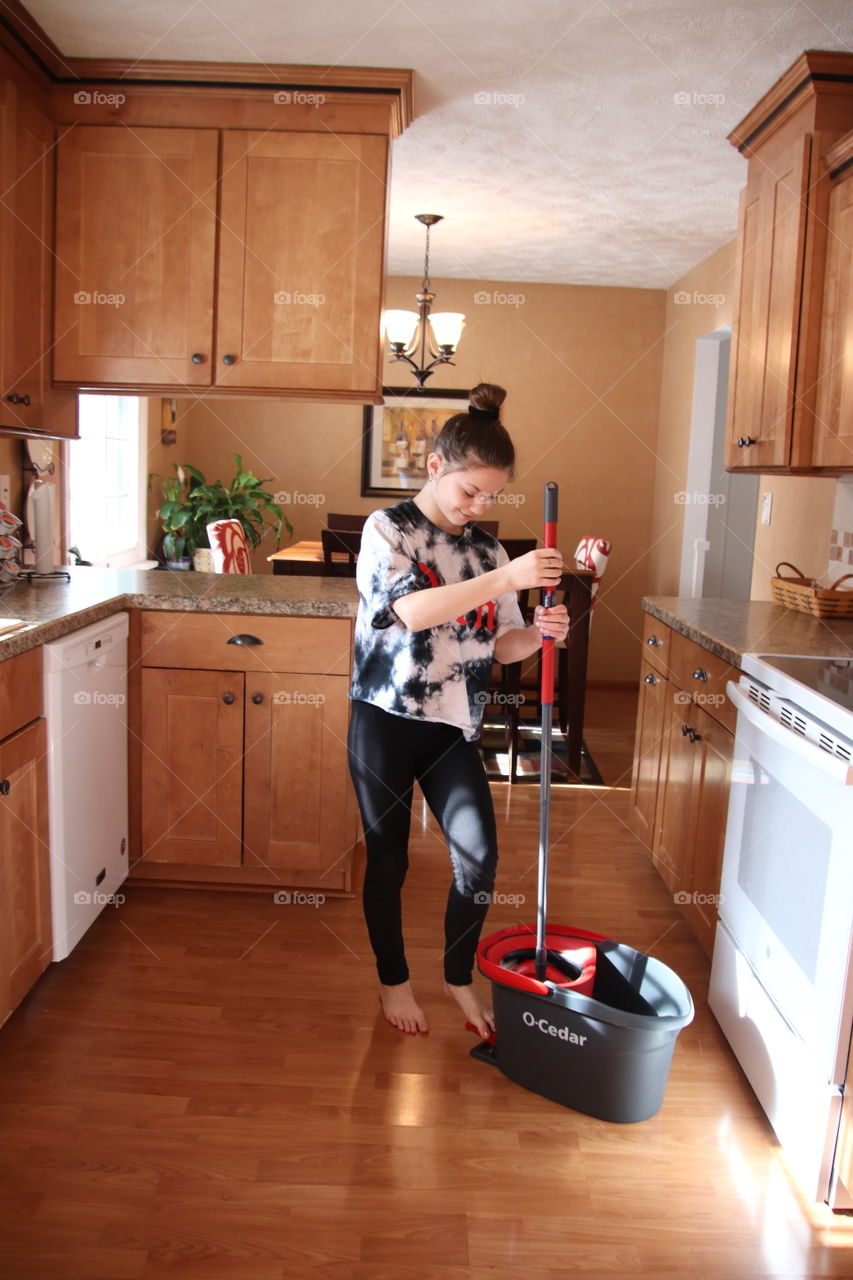 Girl using O-Cedar mop and bucket 