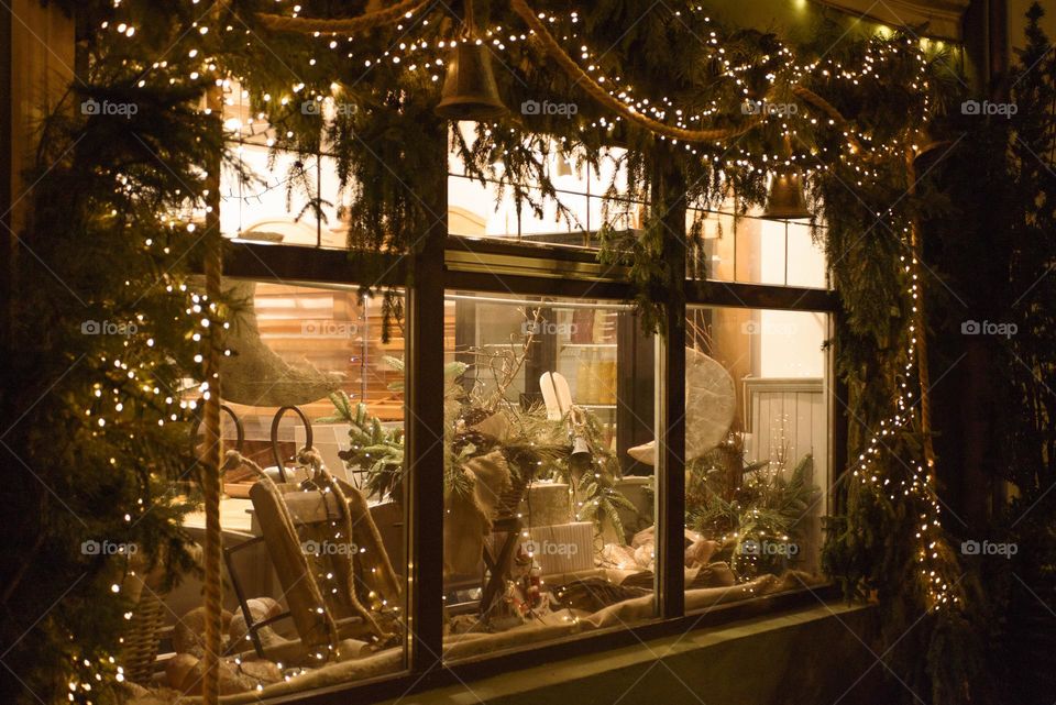 A window in garlands in which New Year's gifts are visible.
