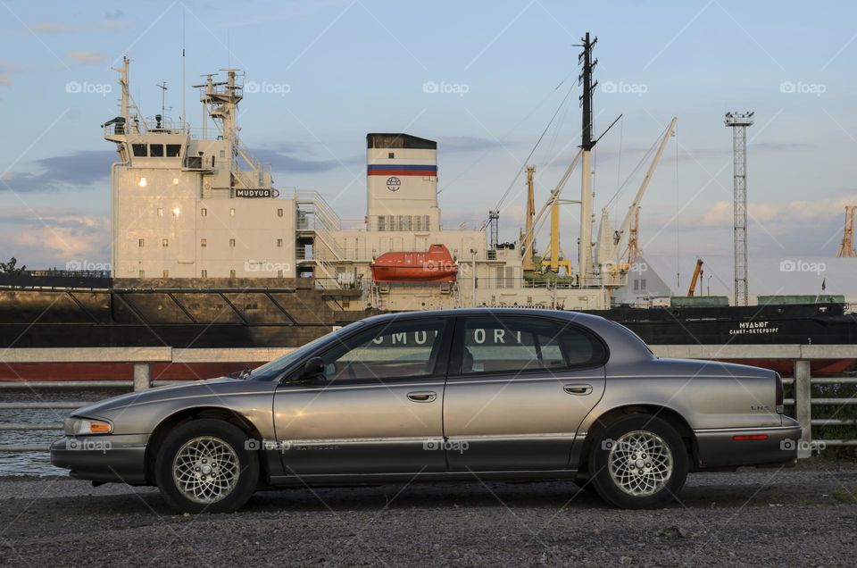 Profile of the Chrysler LHS car in the light of the setting sun on the background of an icebreaker.