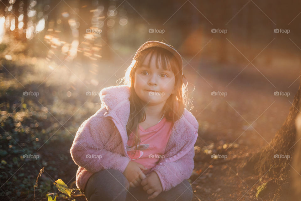 Little girl in evening forest. 