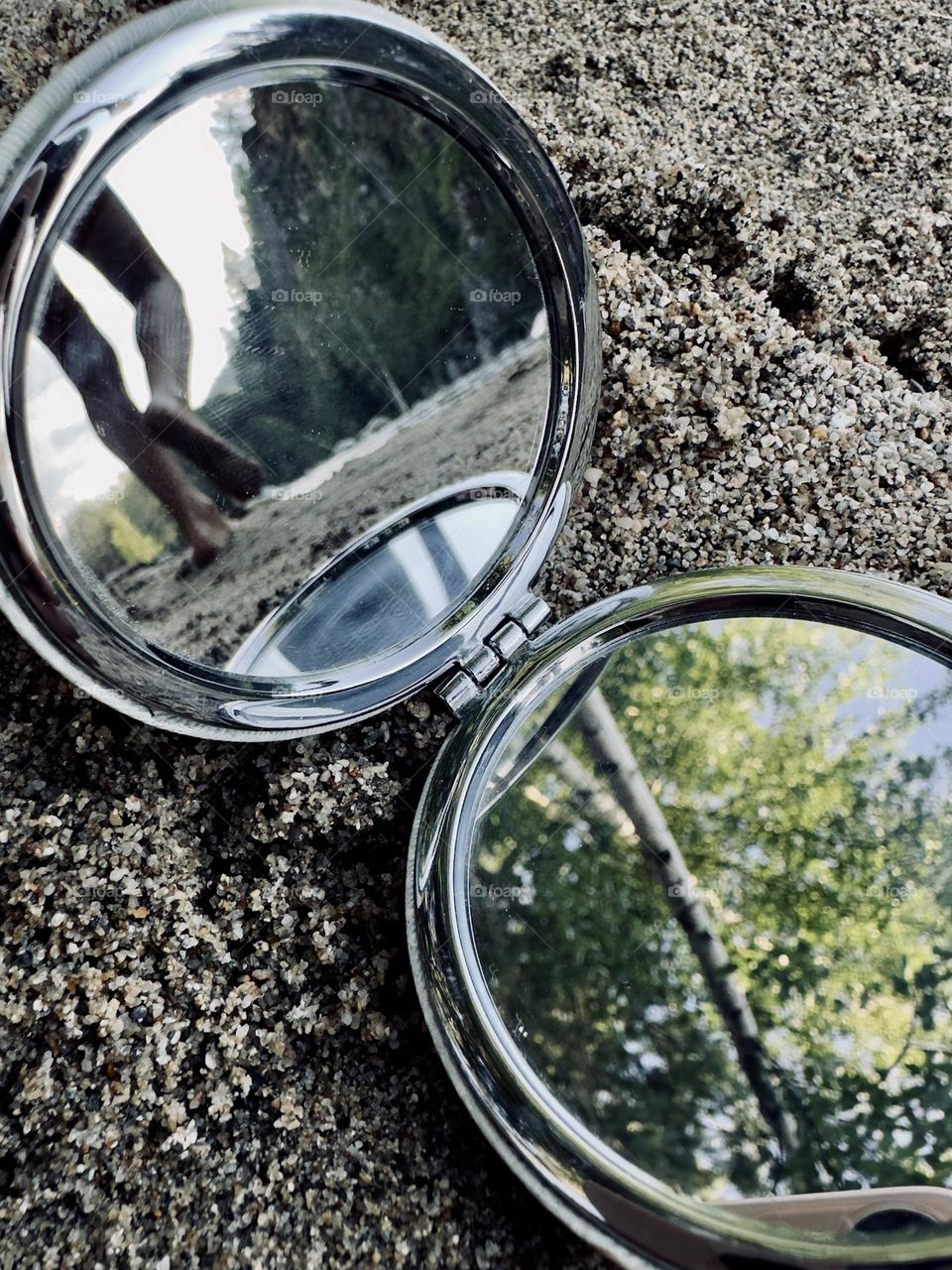 reflection of the child's feet in the mirror on the beach