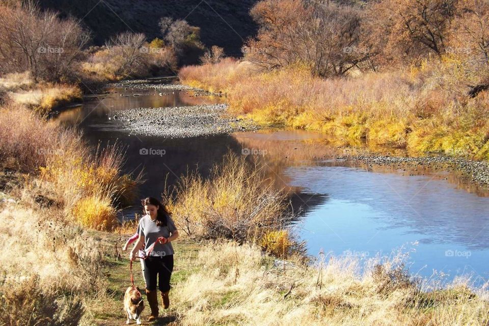 girl and dog running on river path