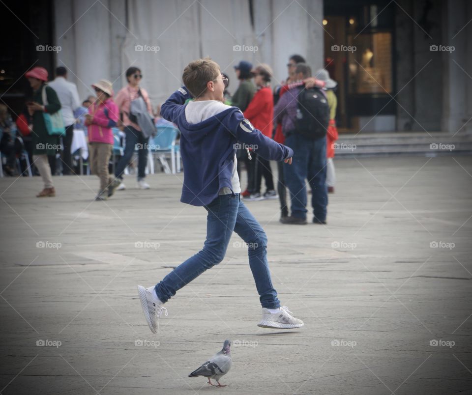 Boy running through St Mark’s Square, Venice Italy