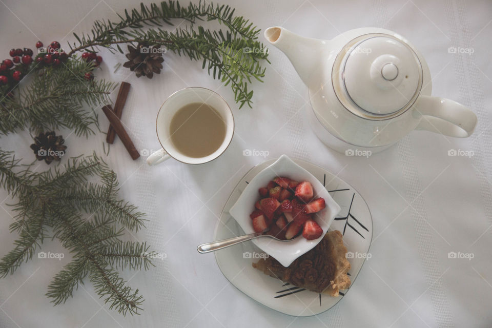 Tea, strawberries and pecan pie in a festive flat lay. Teapot on table