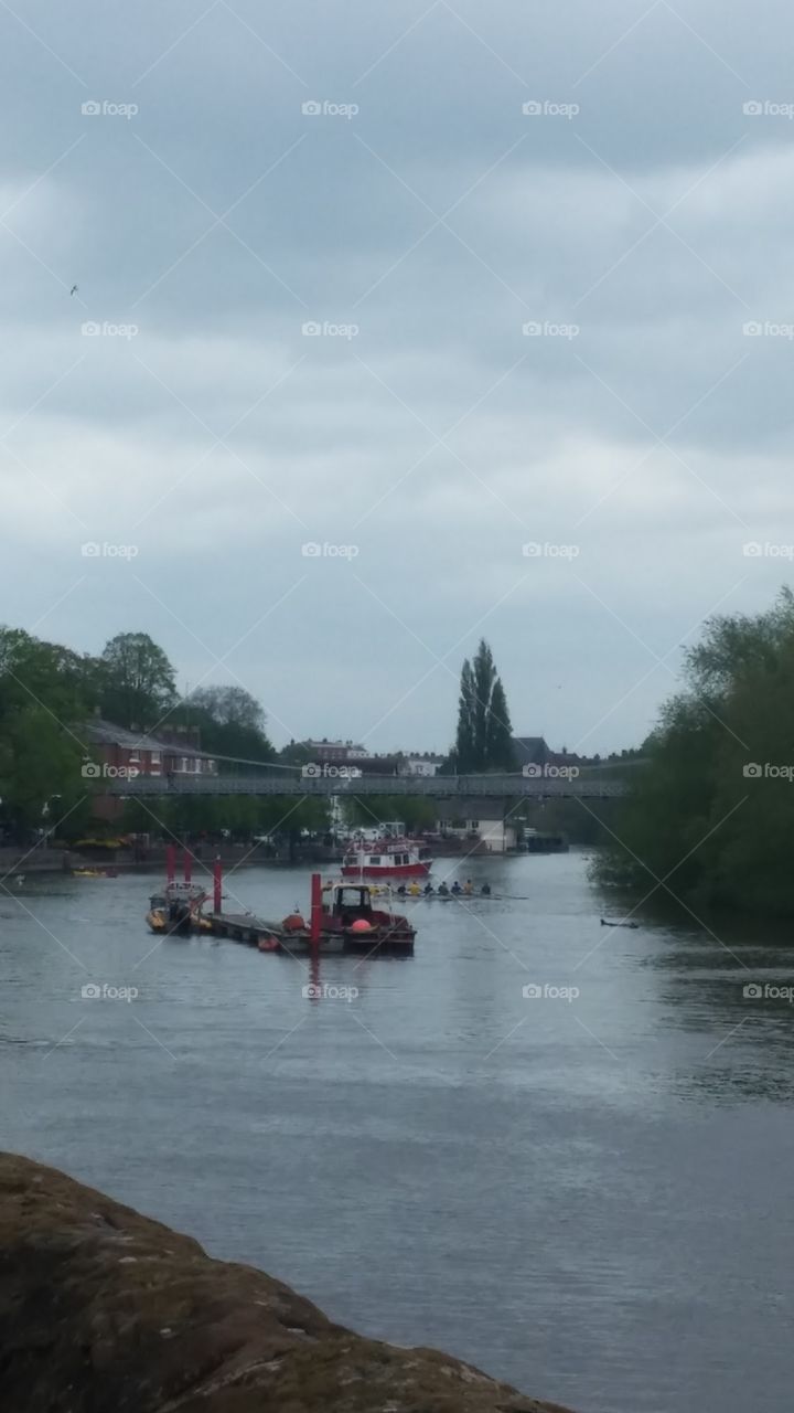 Boats cruising down the River Thames on a cloudy British summer day