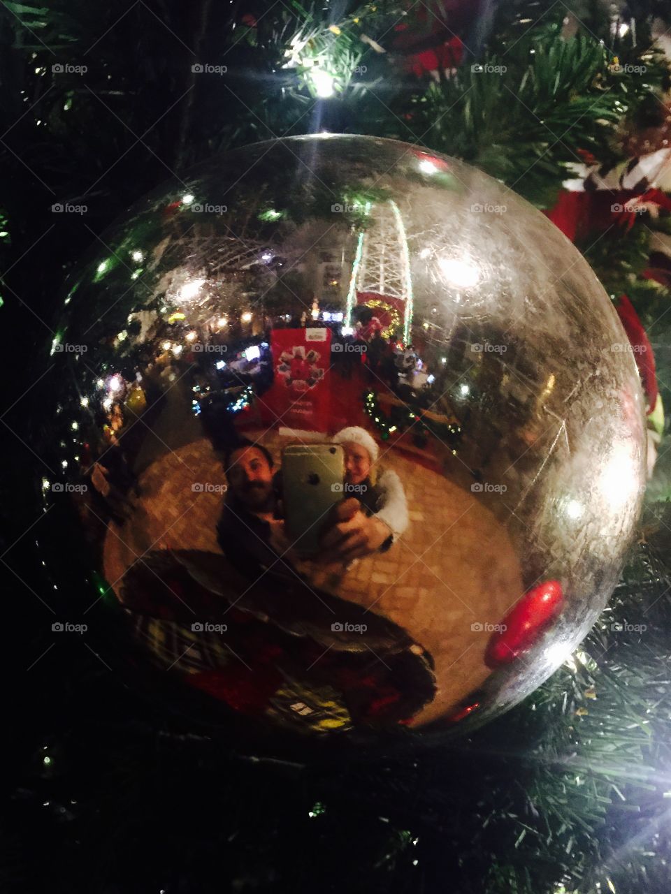 Man and woman reflecting Christmas ornaments