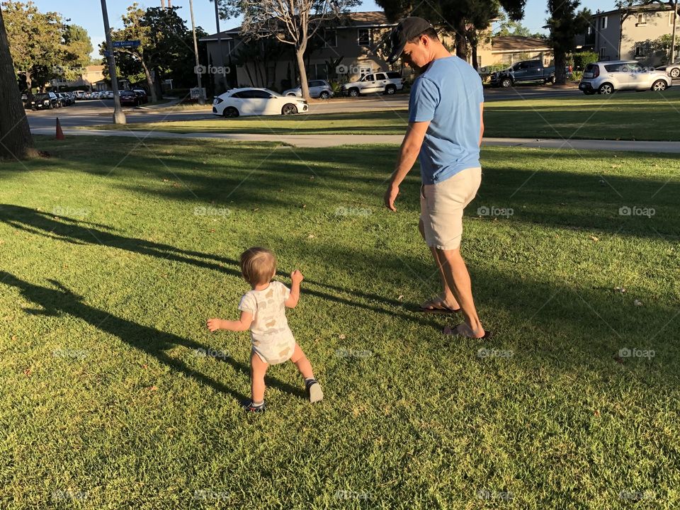 Dad and baby at the park walking 