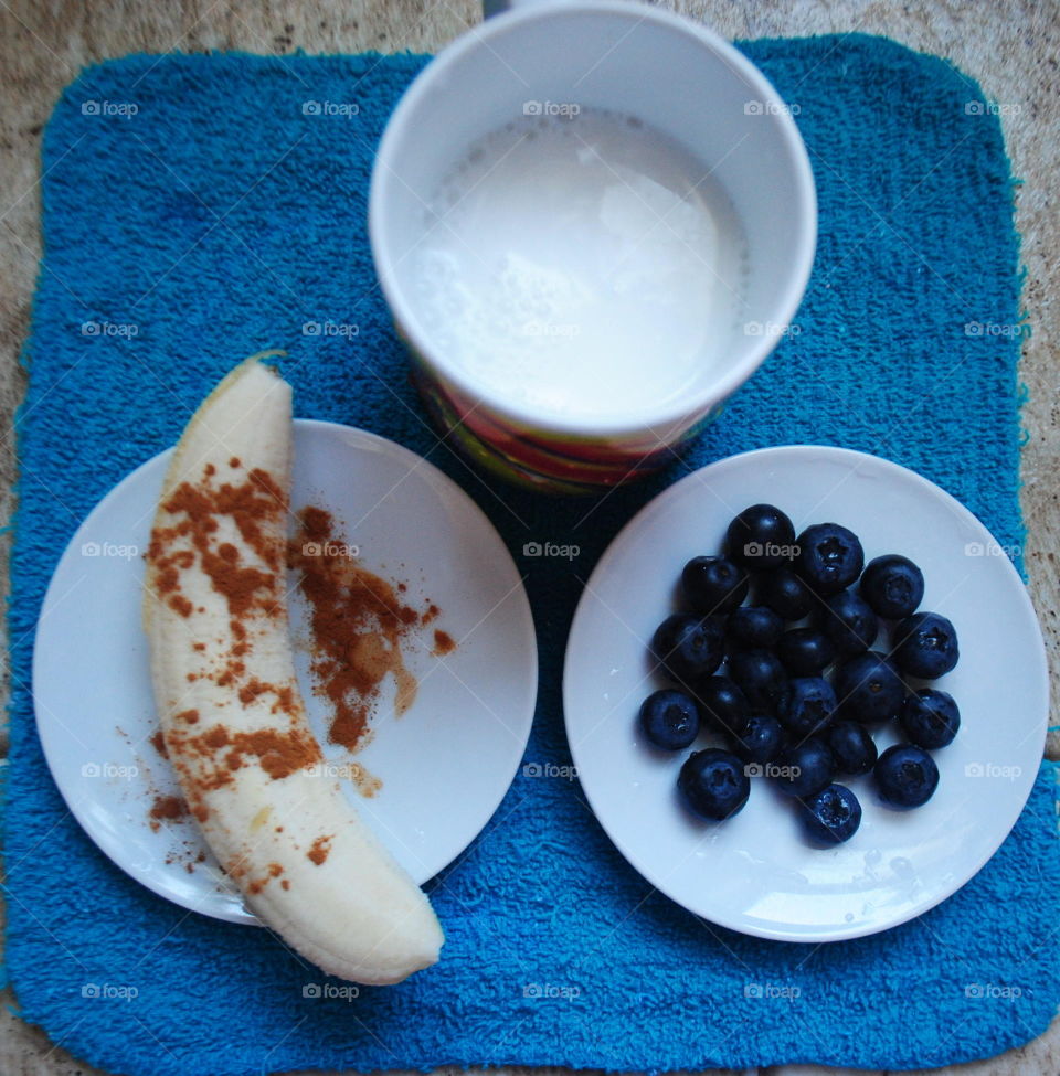 Ingredients for a morning smoothie- banana with cinnamon, blueberries and coconut milk