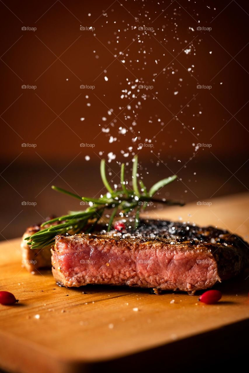 Medium-rare beef steak on a cut. salt is sprinkled on the steak.