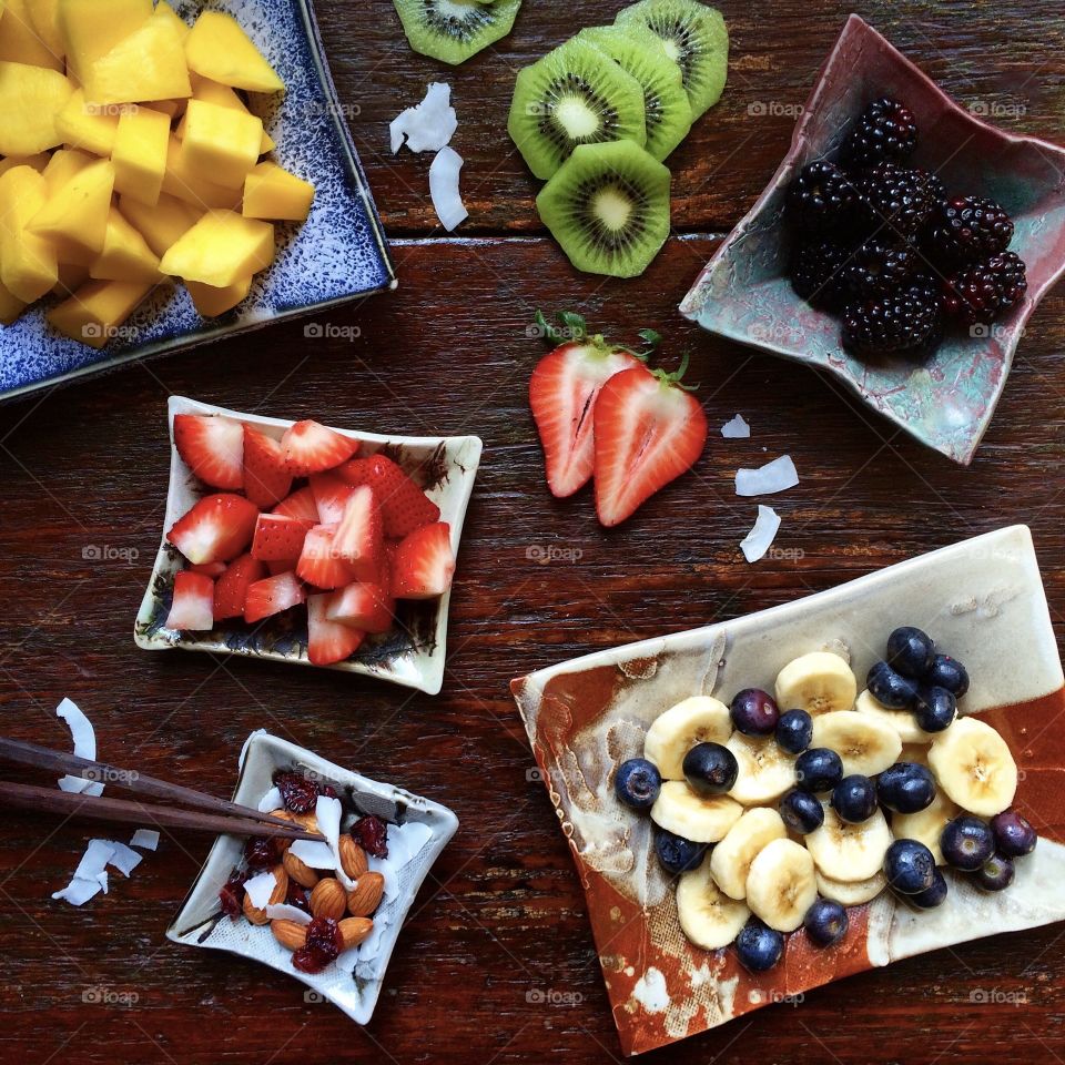Fresh fruit display on individual Asian-style plates.