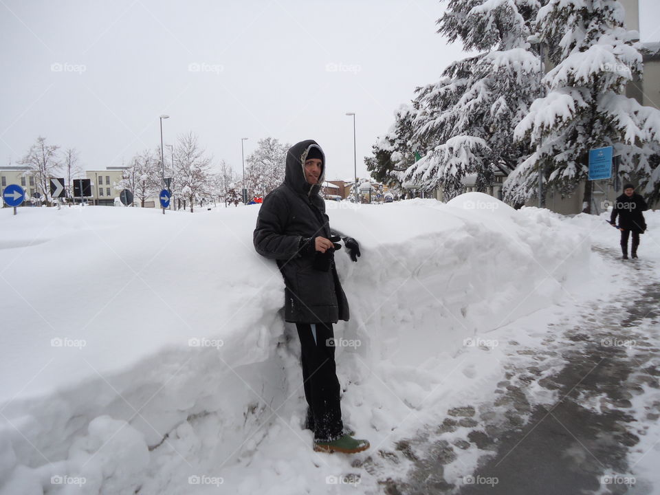 Man walking in a city buried by snow