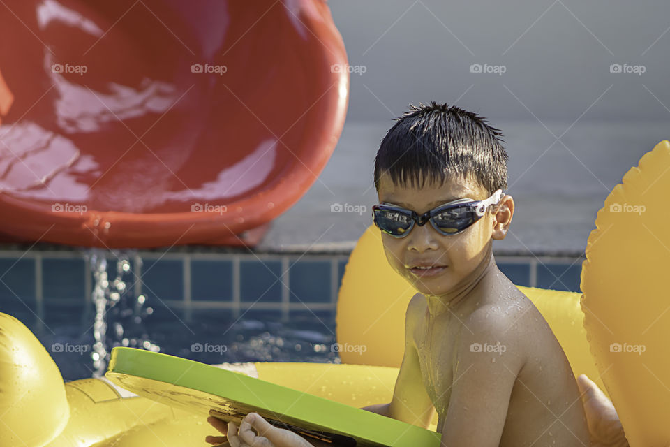 Asian boy is happy playing in the pool.