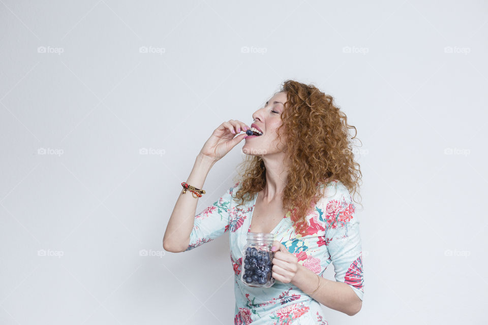 young Beautiful woman woman eating blueberries
