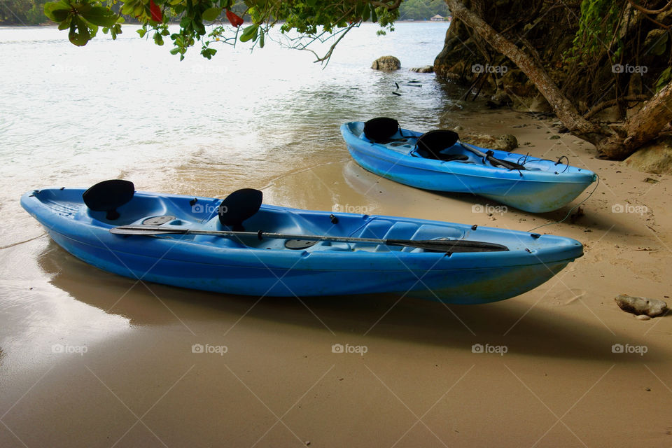Two blue canoes on the beach at the small Monkey Island on the coast of Port Antonio in Portland, Jamaica.