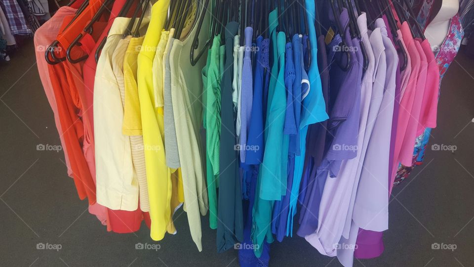 A rainbow of coloured clothes on a rack