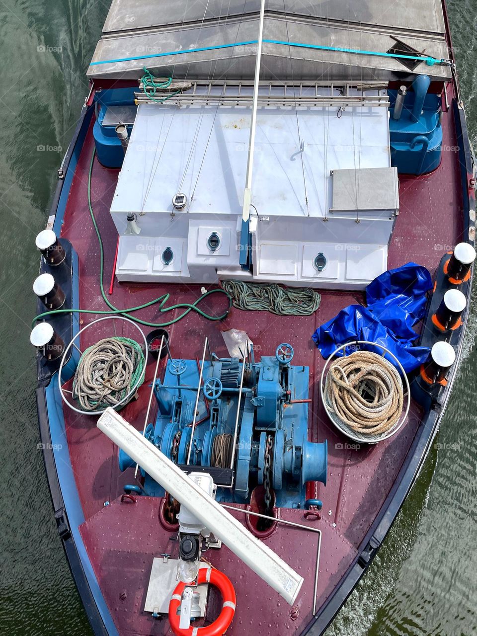 Top view of a cargo ship passing under a bridge
