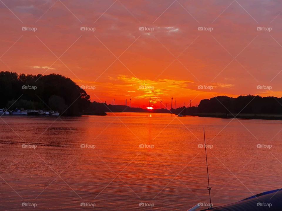 Red evening sun sets, After a warm spring day of 27 degrees. in the Netherlands on the brielse lake.