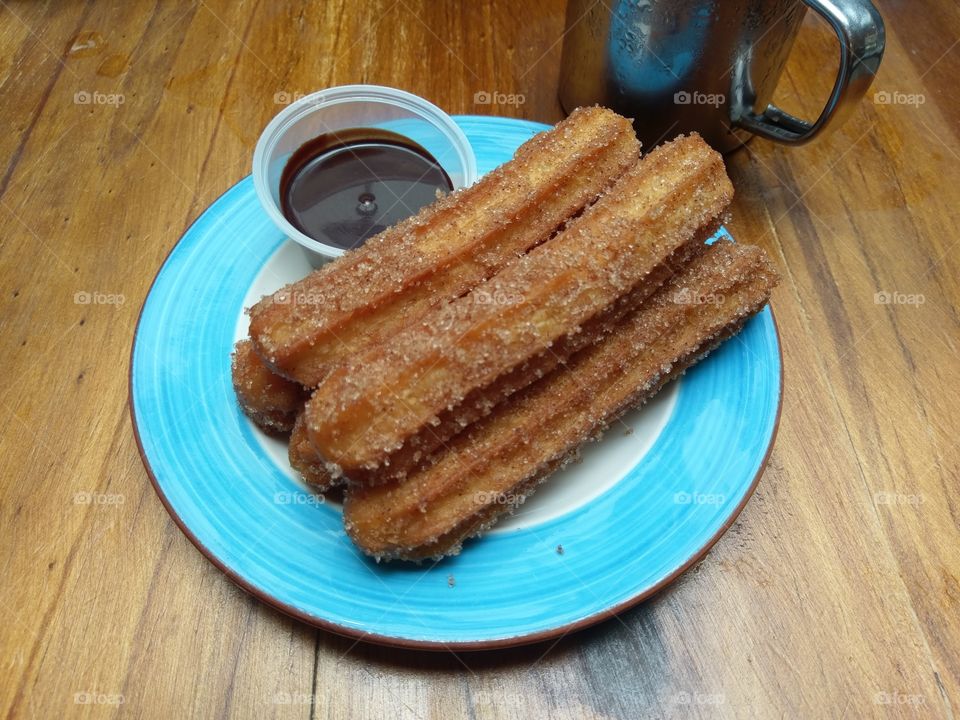 The 5 amigos. Homemade Churros with a side of chocolate dip and a cup of cold coffee sitting chilly behind.