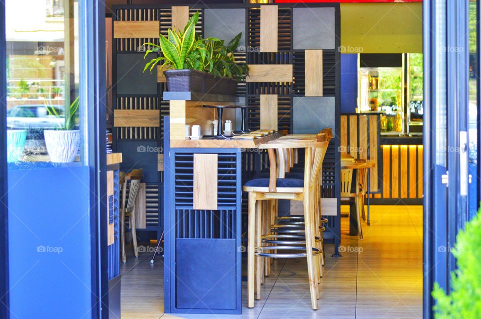 view of the interior of the cafe from the street. bar stools, counter and home furnishings