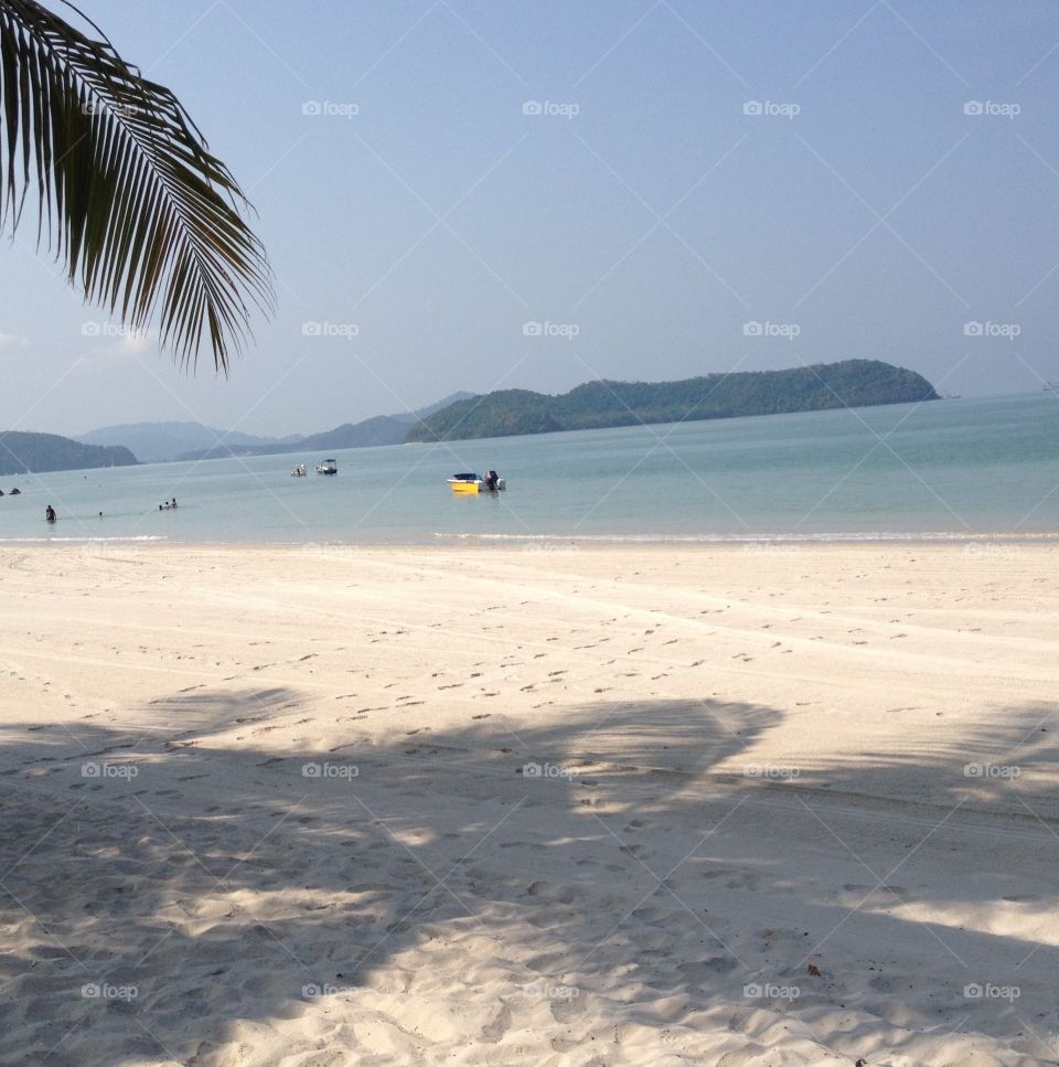 Summer feelings. Enjoying sunshine, a white sandy beach and warm water on Langkawi Island