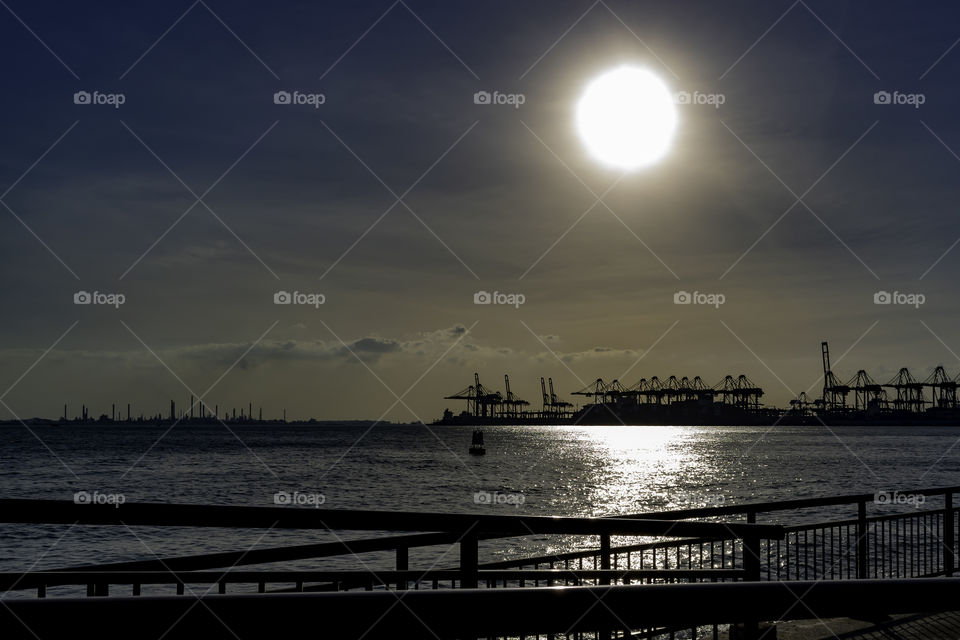 Sunset by the bay with round sun in the sky