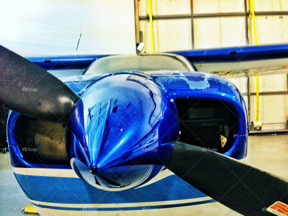 Shiny blue aluminum engine cowling of a Cessna private airplane