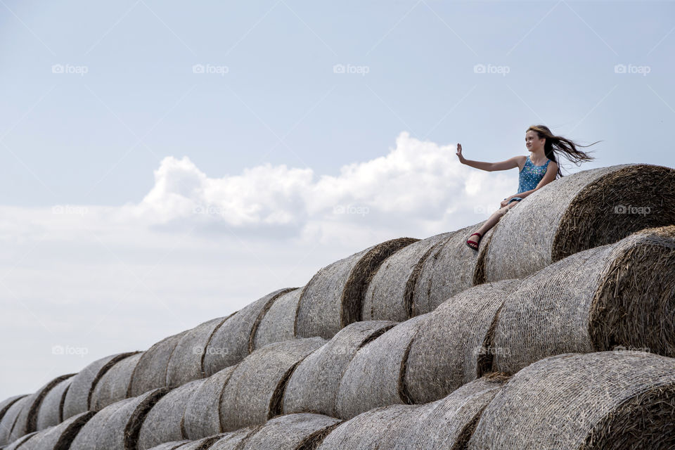 Cute girl touching cloud with her palm. Living in harmony.