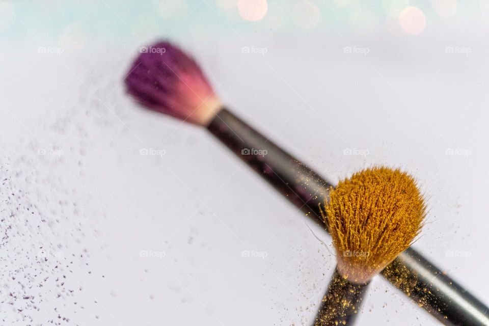 Make up brushes dusting off the eye shadows